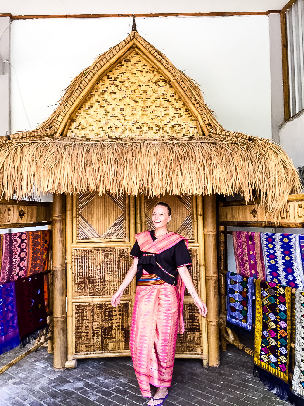 Lombok: Sukarara Weaving Village - tourist dressed in traditional Sasak clothing at the Patuh Art Shop.