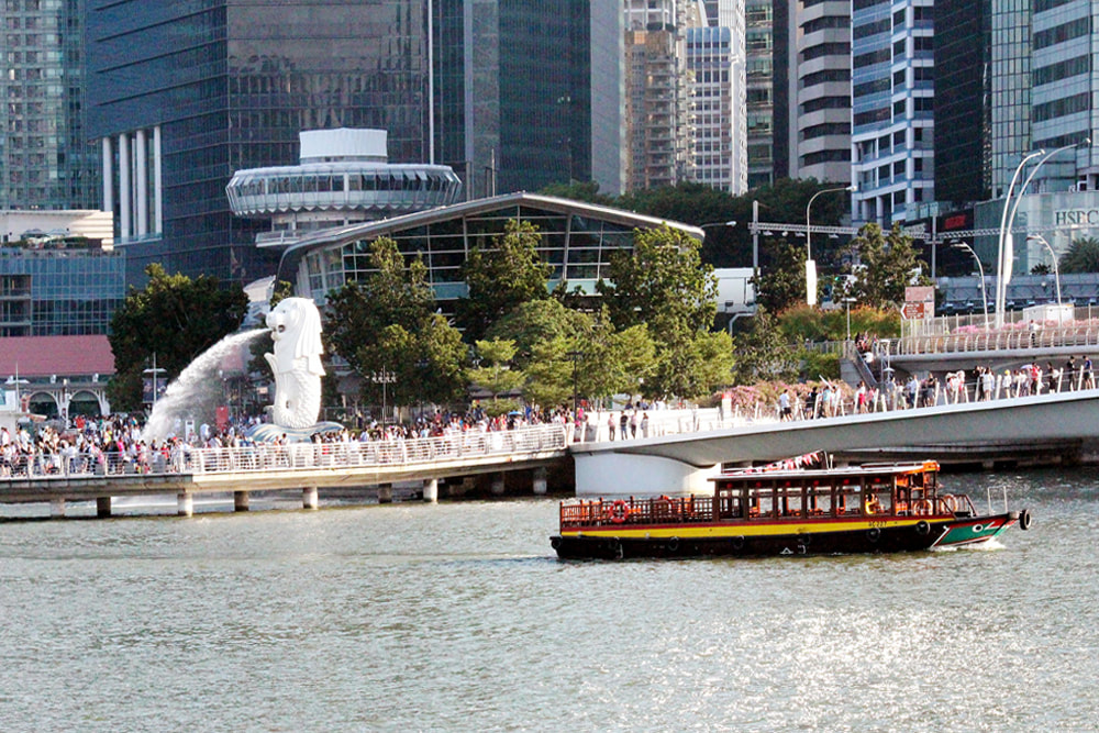 An historic bumboat cruising past Merlion Park, Singapore.