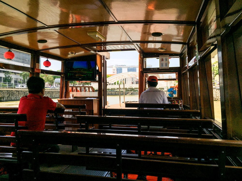 The interior of the historic bumboat with the tour guide and driver - Singapore River Cruise.