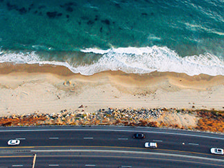 Using Transport to Transform Your Trips. Drone photo of freeway and beach.