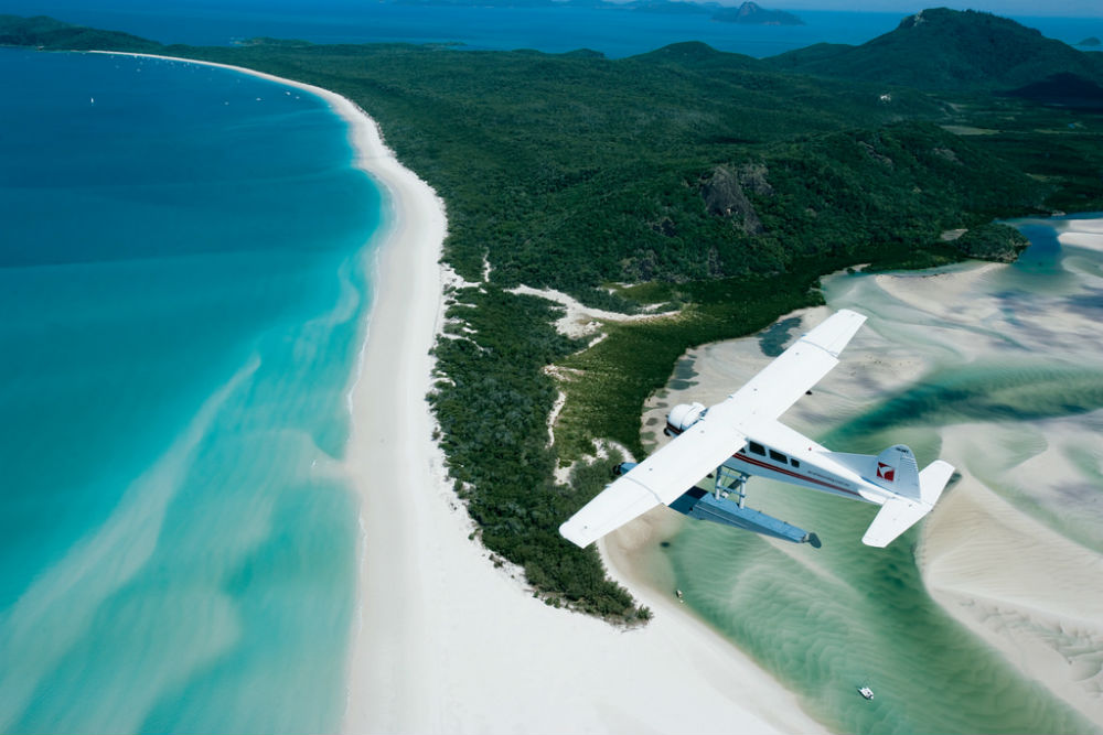 4 Incredible Islands to Visit in Australia - A seaplane flying over Whitehaven Beach, Whitsunday Islands, Queensland, Australia.