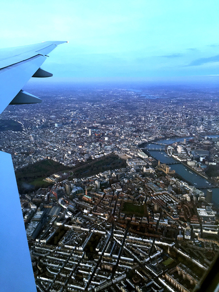 An aerial birds eye view of London - Flying with Qatar Airways past the River Thames, the London Eye, Big Ben, Houses of Parliament, Westminster Abbey and Buckingham Palace - Tily Travels.