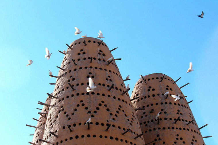 Qatar Airways free Doha city tour - Katara Cultural Village dovecote with doves in flight.