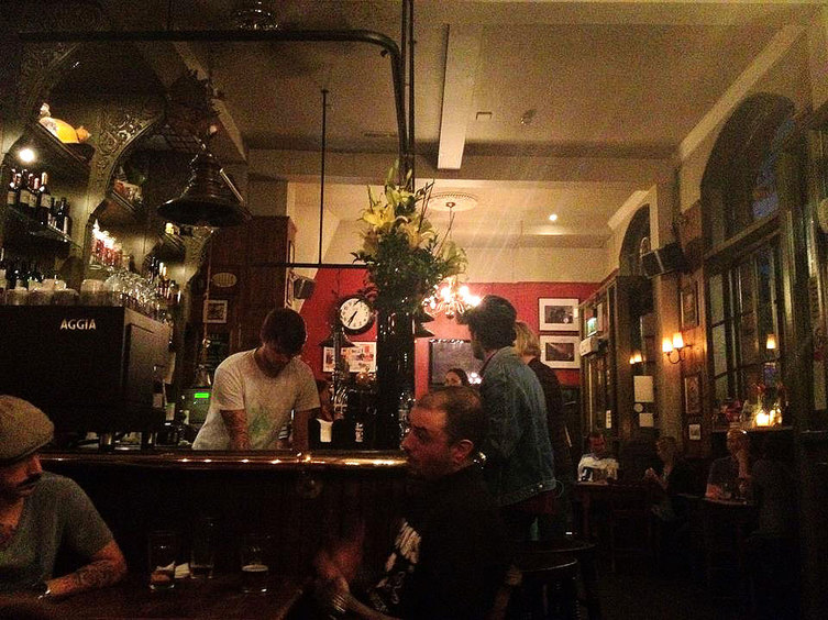 The dimly lit main bar at the Hawley Arms - Camden Town, London England - Tily Travels.