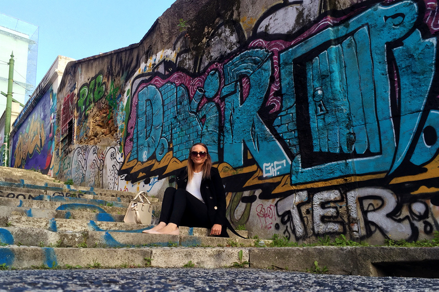 Sitting in front of colourful street art and graffiti on the Calcada do Lavra stairs, Lisbon, Portugal - Calçada do Lavra street art.