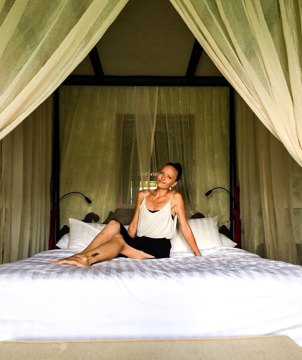 Relaxing on the 4 poster bed inside the Govardana Villa. Dwaraka, the Royal Villas, Ubud, Bali, Indonesia.