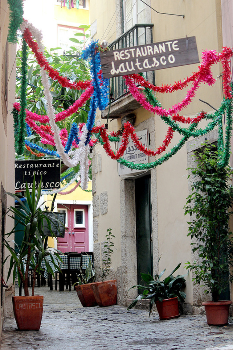 Colourful bunting hanging in the alfresco dining area of Restaurante Lautasco - Alfama, Lisbon - Portugal.
