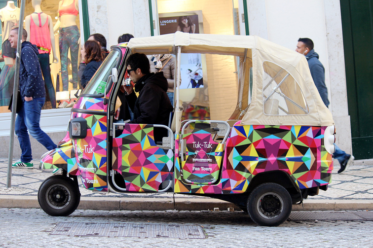 Lisbon Tuk Tuk Fun Tours guide awaits passengers on Rua Garrett - Chiado, Lisbon - Portugal.