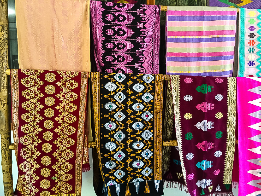 Lombok: Sukarara Weaving Village - Colourful songket motif sarongs.