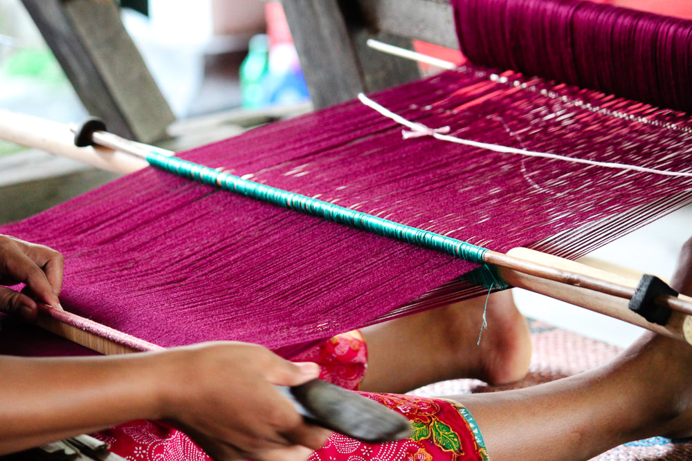 Lombok: Sukarara Weaving Village - Close up of a woman working using a traditional loom at the Patuh Art Shop.