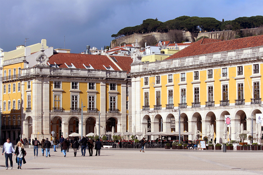 Traditional yellow painted portuguese architecture and the São Jorge Castle (Castelo de São Jorge/ Saint George Castle), Praca do Comercio, Lisbon, Portugal.