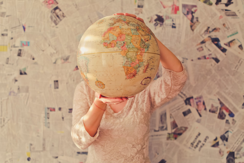 Here’s How You Can Travel Solo and Have Fun Every Step of the Way. Girl with globe.